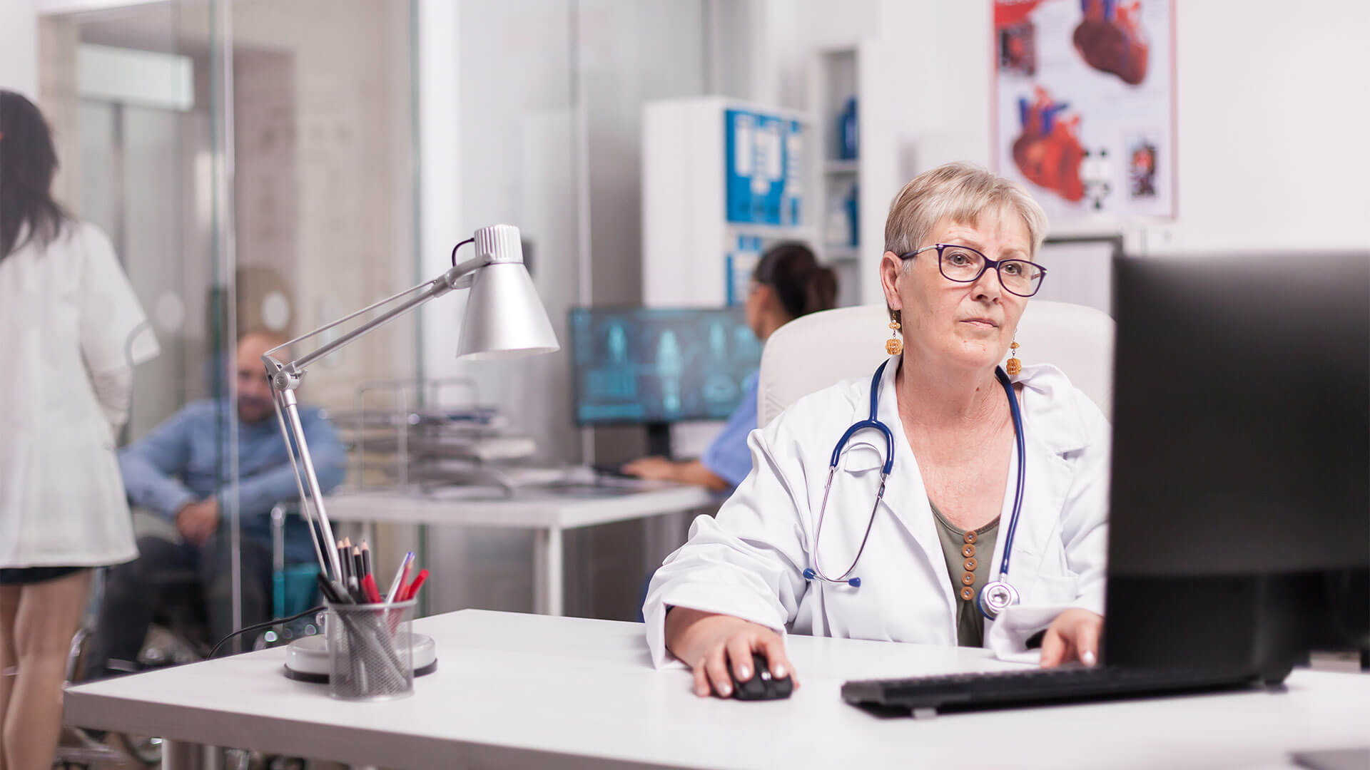 Mulher médica 60+ trabalhando em computador, representando Como o Auxílio-Acidente afeta a Aposentadoria